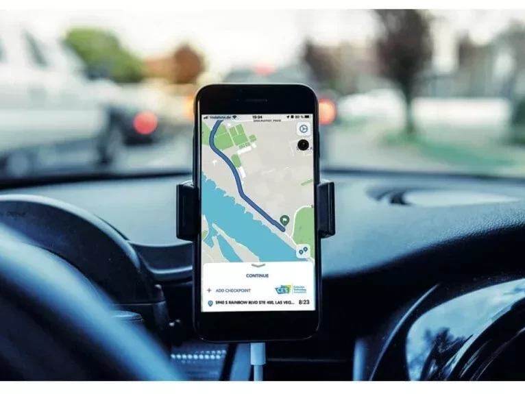 Armaturenbrett im Auto mit Smartphone und Navigationsapp in einer Halterung.