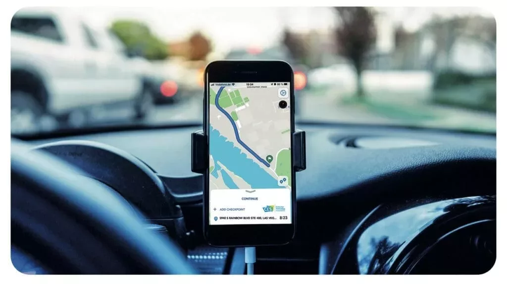 Armaturenbrett im Auto mit Smartphone und Navigationsapp in einer Halterung.