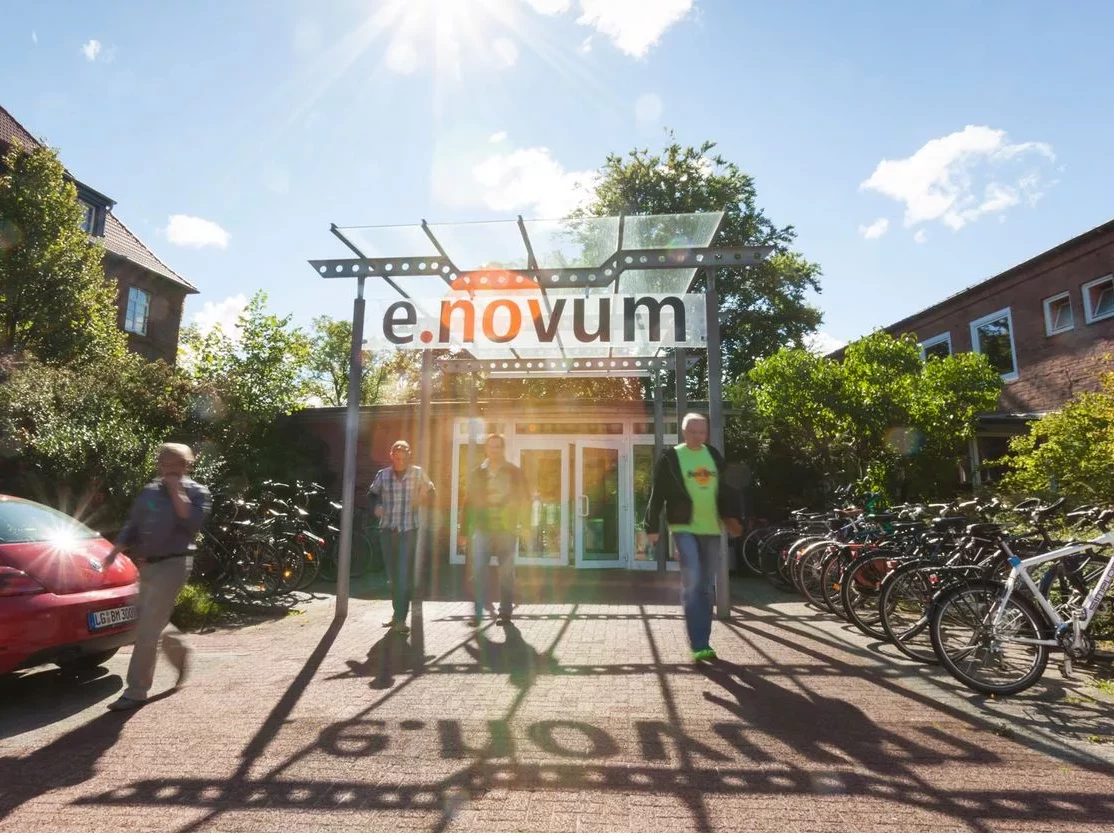 Eingang e.novum und Menschen davor.