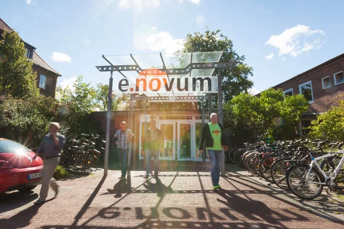 Eingang e.novum und Menschen davor.