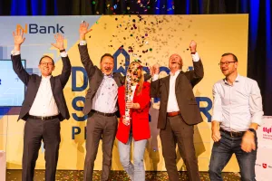 Das Bild zeigt vier Männer und eine Frau, die auf der Bühne der DurchSTARTER-Preisverleihung eine Konfetti-Kanone abfeuern.