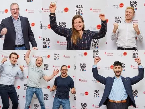 Das Bild zeigt die Gewinner des Startup Impuls Wettbewerbs vor einer Logowand.
