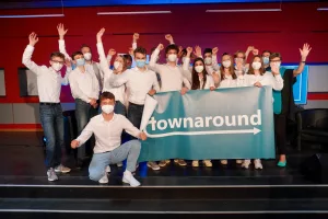 Eine Gruppe Schüler*innen feiern ihren Erfolg auf der Bühne.