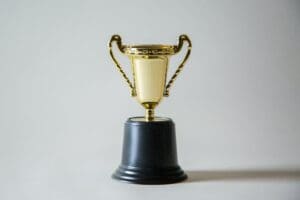 Das Bild zeigt einen Pokal auf einem hellgrauen Hintergrund.