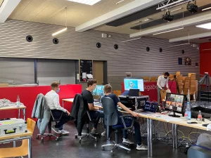 Das Bild zeigt drei Schüler die vor der Aufnahmetechnik sitzen.