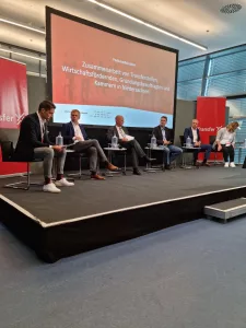 Podiumsdiskussion auf der Bühne beim Transfer X Summit.