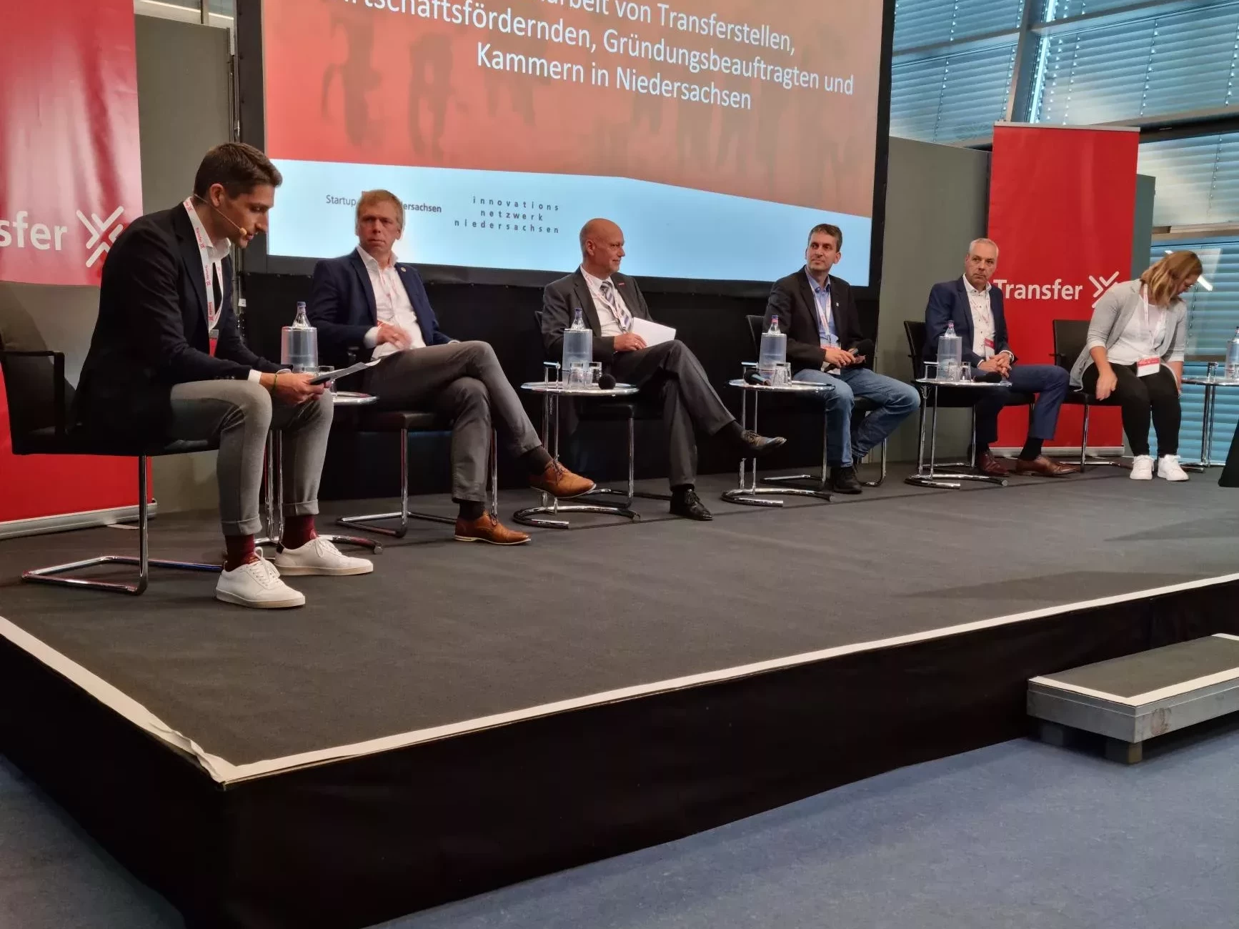 Podiumsdiskussion auf der Bühne beim Transfer X Summit.