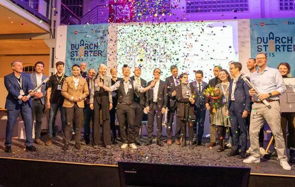 Die Gewinner*innen des DurchSTARTer-Preises stehen auf der Bühne und schmeißen Konfetti.