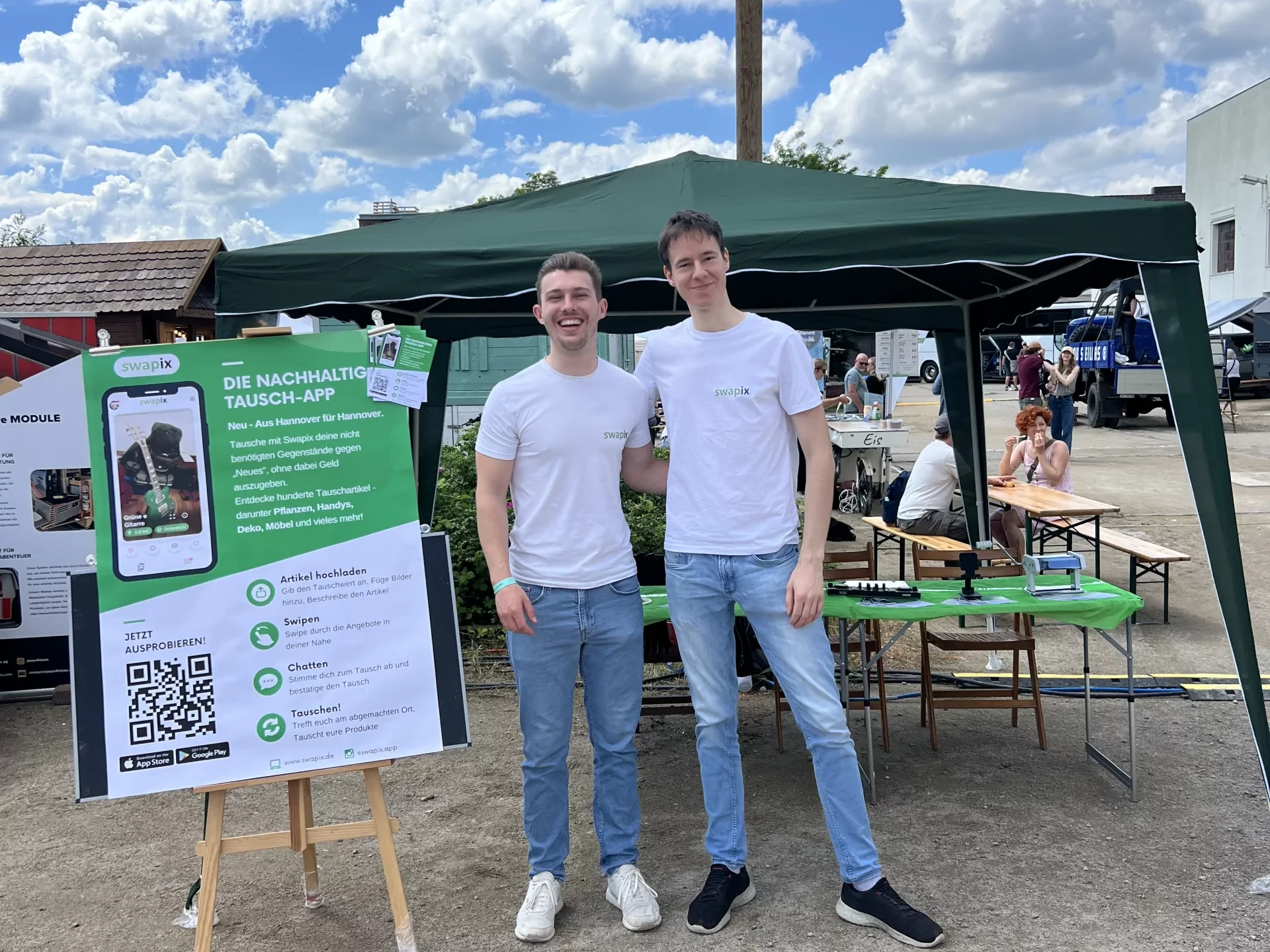 Zwei Gründer auf einer Camöingmesse draußen vor ihrem Stand
