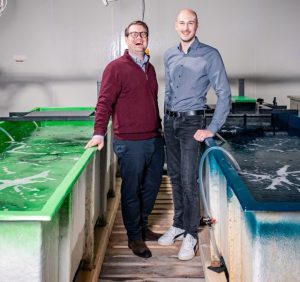 Zwei Männer in der Mitte von zwei Becken zur Garnelenzucht